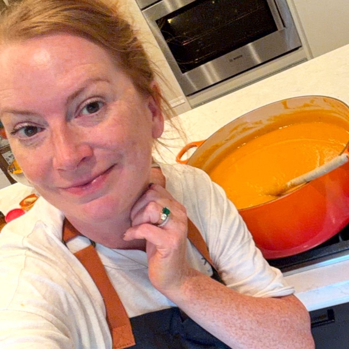 Heather in her kitchen beside a big orange pot of soup