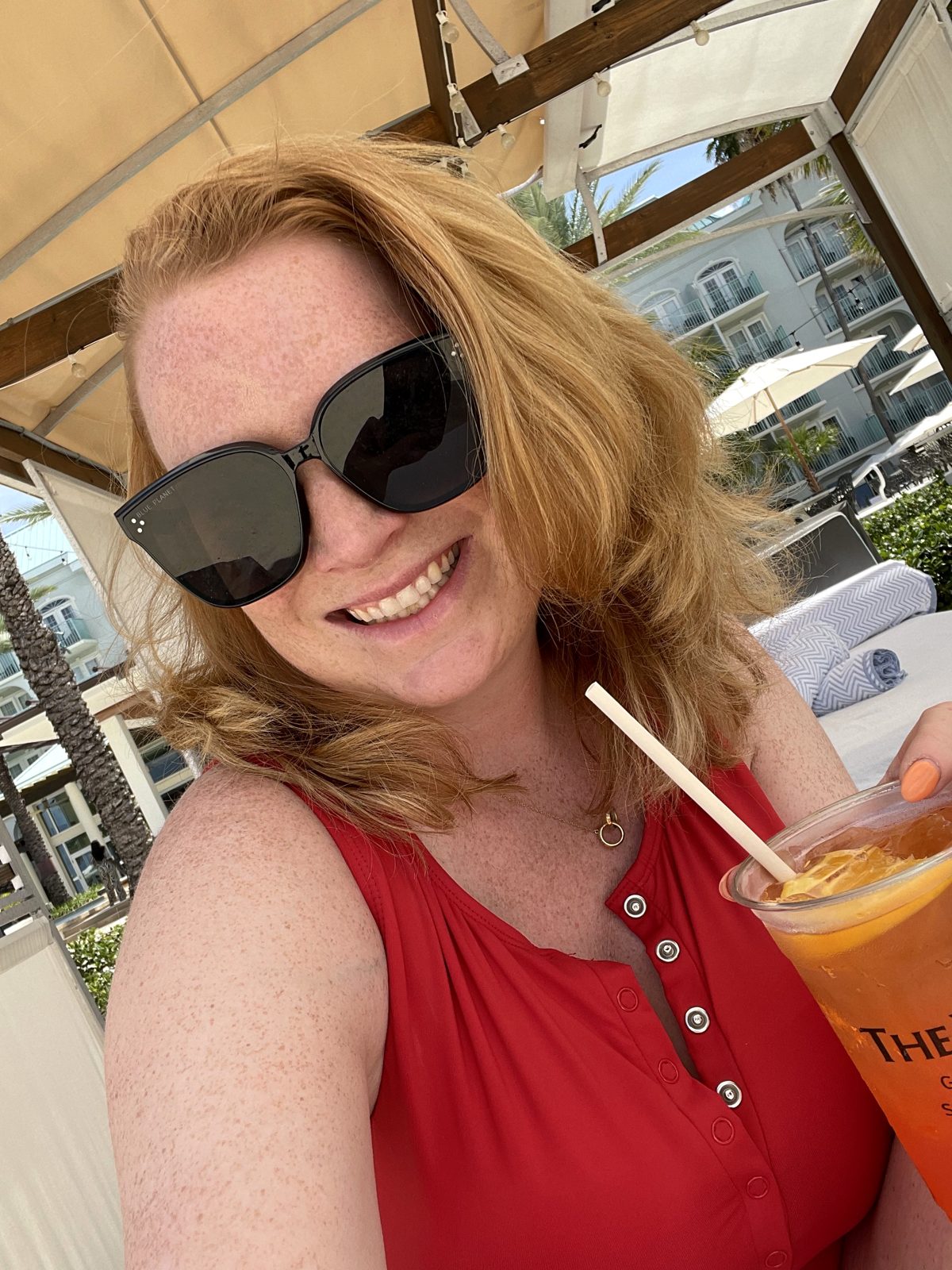 A frozen cocktail held up under a beach cabana