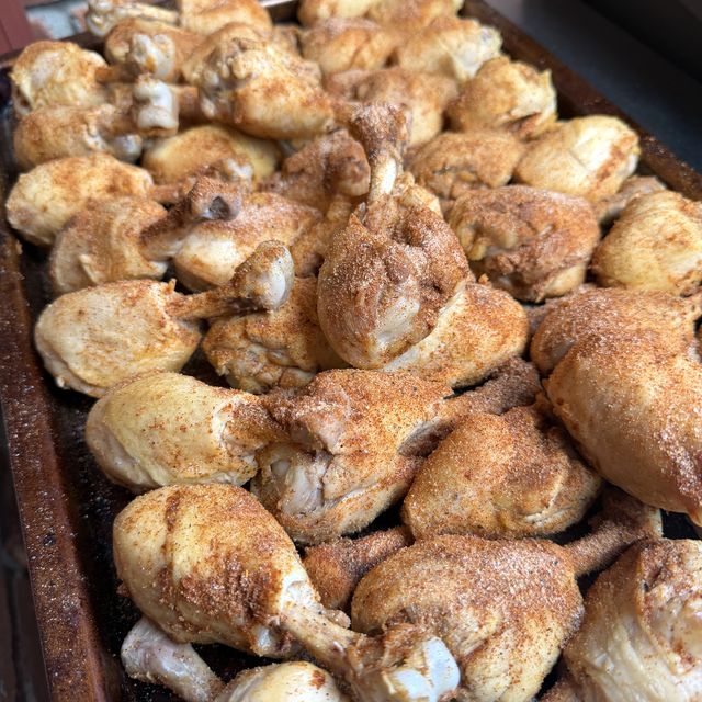 Cooked drumsticks coated in paprika seasoning on a sheet pan