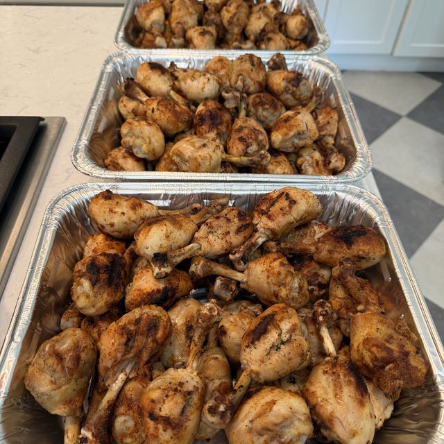 Foil trays of sauced drumsticks ready to serve