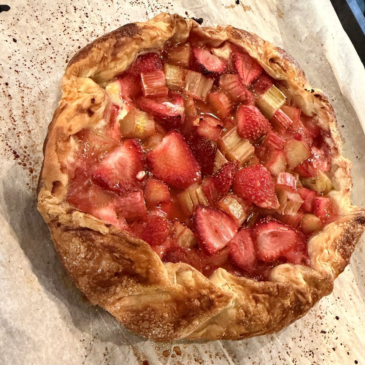 Baked strawberry rhubarb galette with a golden, flaky puff pastry crust